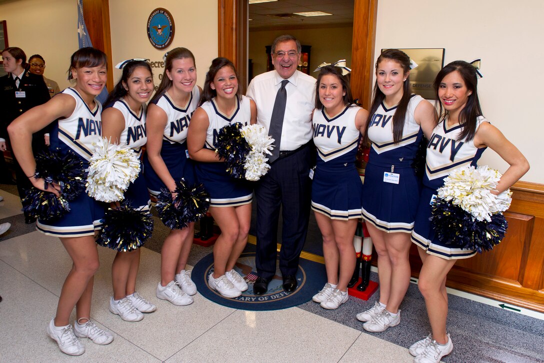 Defense Secretary Leon E. Panetta poses for photos with the U.S. Naval Academy Midshipmen cheerleaders and band during a pep rally held in the halls of the Pentagon, Dec. 6, 2012.