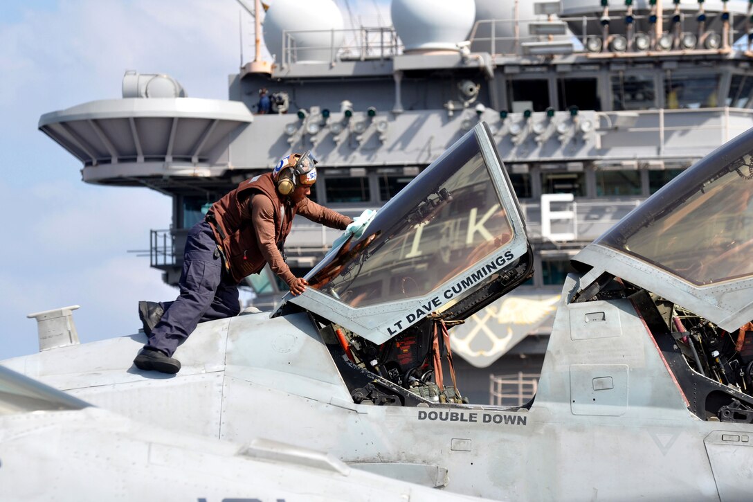 Navy Airman Jay Abraham cleans the canopy of an EA-6B Prowler on the flight deck aboard the USS Dwight D. Eisenhower in the Arabian Sea, Nov. 25, 2012. The Dwight D. Eisenhower is deployed to the U.S. 5th Fleet area of responsibility conducting maritime security and support missions as part of Operation Enduring Freedom. Abraham is assigned to the Patriots of Electronic Attack Squadron 140. 