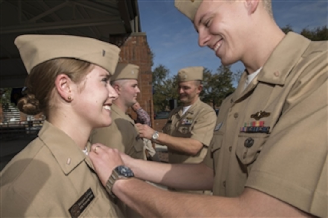 U.S. Navy Lt. j.g. Luke Leveque, right, pins the submarine officer warfare device on his wife Lt. j.g. Marquette Leveque, left, at Naval Submarine Base Kings Bay, Ga., on Dec. 5, 2112.  Marquette Leveque is one of the first three female unrestricted line officers to qualify in submarines.  Marquette is assigned to the Gold crew of the ballistic missile submarine USS Wyoming (SSBN 742) and her husband Luke is assigned to the Gold crew of the ballistic missile submarine USS Maryland (SSBN 738).  