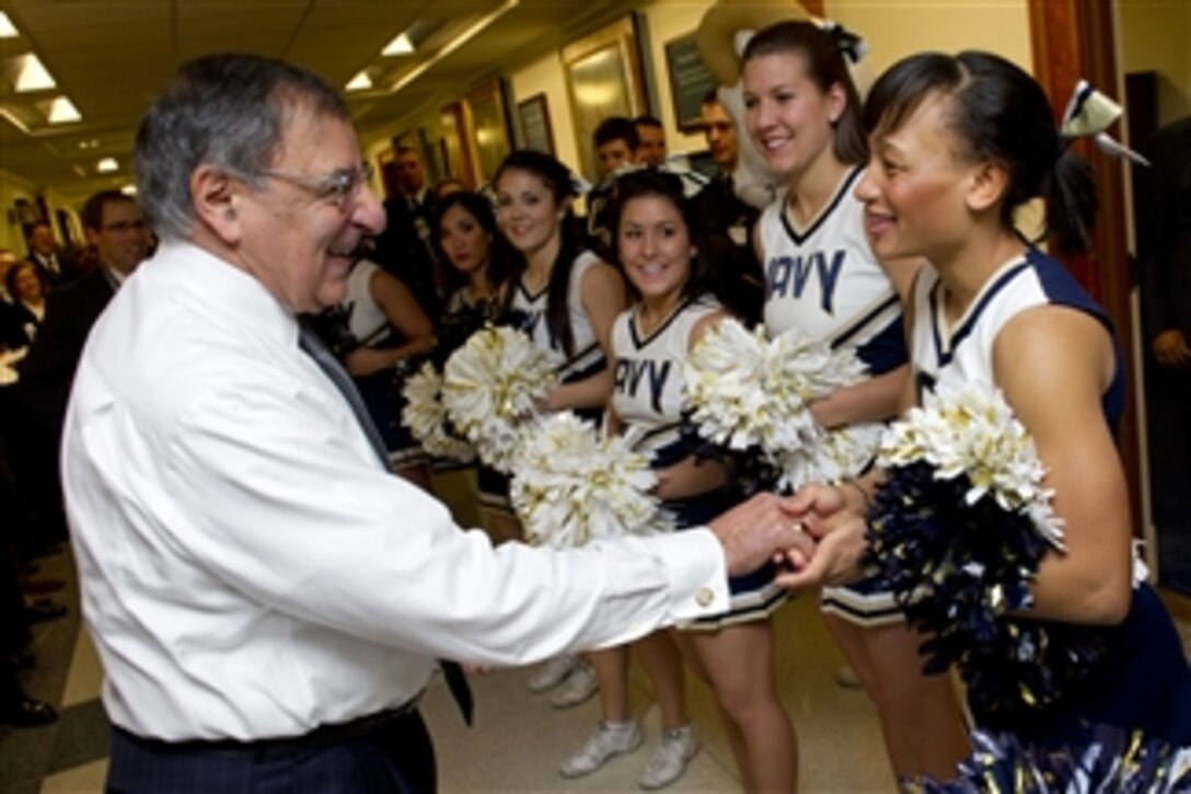 Secretary of Defense Leon E. Panetta greets the U.S. Naval Academy Midshipmen cheerleaders and band during a pep rally held in the halls of the Pentagon on Dec. 6, 2012.  The Naval Academy Midshipmen take on the West Point Black Knights in the 113th meeting between the two service schools at Philadelphia's Lincoln Financial Field on Saturday, Dec. 8th.  