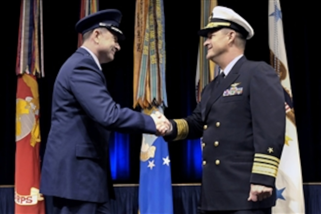 Incoming F-35 Program Executive Air Force Lt. Gen. Christopher C. Bogda, left, shakes hand with retiring Navy Vice Adm. David J. Venlet, right, during an F-35 Change of Program Executive and retirement ceremony in the Pentagon auditorium, Dec. 6, 2012. Deputy Defense Secretary Ashton B. Carter also attended the event.