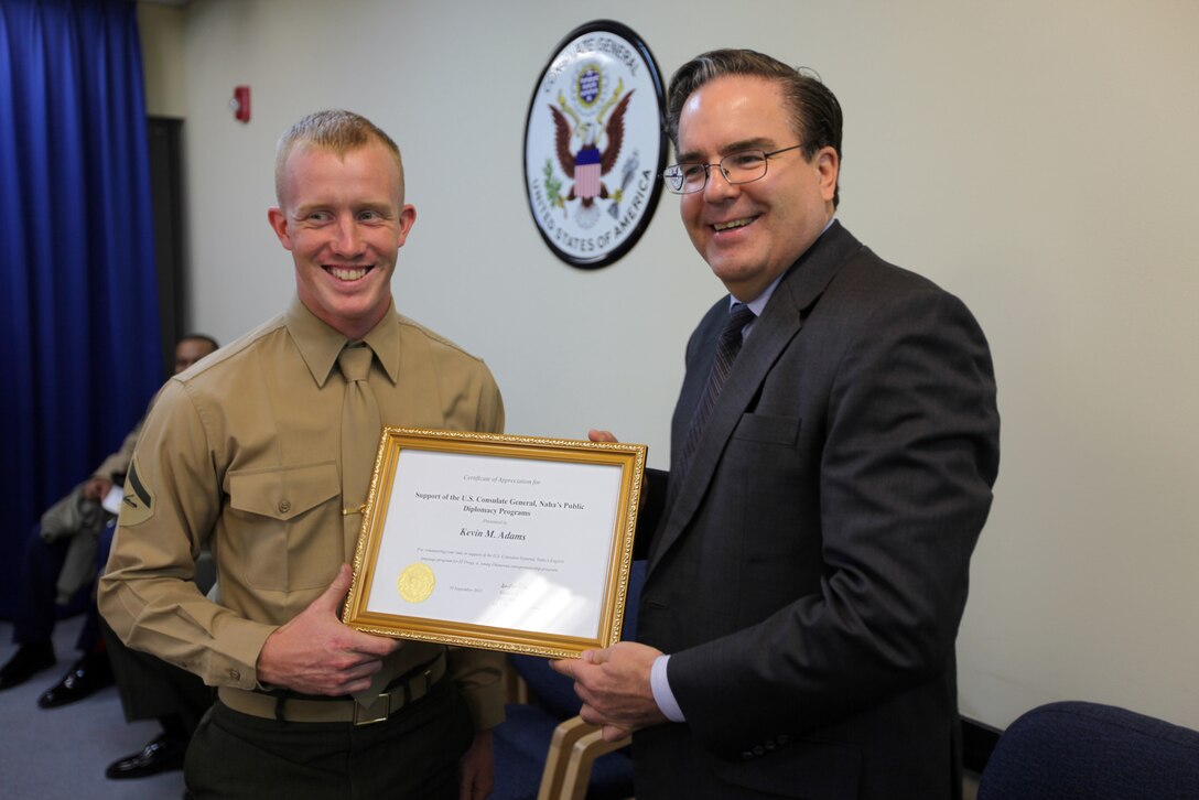 Lance Cpl. Kevin M. Adams, a CH-46E mechanic for Marine Medium Helicopter Squadron 262 (Reinforced), 31st Marine Expeditionary Unit, and native of Covington, Ga, accepts a certificate of appreciation from U.S. Consul General Alfred R. Magleby here, Dec. 5. The service members spent several weeks volunteering their time to teach English to Okinawa students in local information technology schools and were commended by the U.S. Consul General for their community service. The 31st MEU is the Marine Corps’ force-in-readiness for the Asia-Pacific region and the only continuously forward-deployed MEU. 