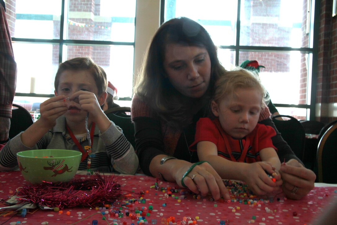 Austin Keelty Jr., 7, Adeline, 3, and their mother Maggie make festive beaded necklaces during the "Breakfast with Santa," event Dec. 1. The event was hosted by the CarolinaEast Foundation and provided a free holiday experience for 15 military families.


