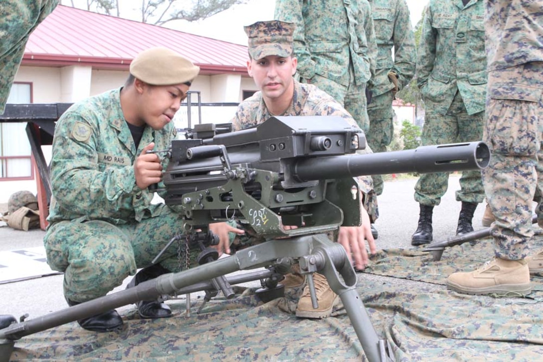 Lance Cpl. Ewing Joshua, a machine-gunner serving with 2nd Battalion, 5th Marine Regiment, explains the capabilities of the Mark 19 grenade launcher to Singaporean Guardsman Lance Cpl. Muhad Raiz, a rifleman serving with 3rd Battalion Singapore Guards, here, Nov. 29, 2012. Valiant Mark is an annual exercise that improves the ability of Marines to train and operate with their allies in the Pacific. (Official United States Marine Corps photo by Lance Cpl. Corey Dabney.)