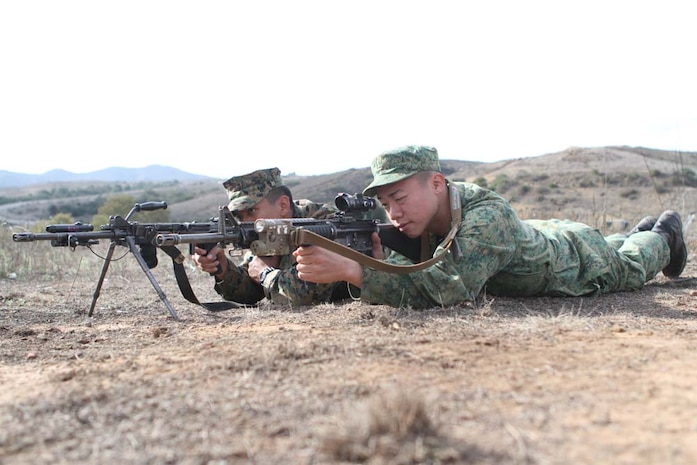 Lance Cpl. Chin Wanfeng, a rifleman serving with 3rd Battalion Singapore Guards, exchanges weapons with Lance Cpl. Christopher Elk, a rifleman serving with 2nd Battalion, 5th Marine Regiment, to examine the differences in sensitivity of trigger mechanisms here, Dec. 1 during Exercise Valiant Mark 2012. Wanfeng said the M16A4 service rifle has a softer trigger-pull than his Mark 3 general purpose machine gun. (Official United States Marine Corps photo by Lance Cpl. Corey Dabney.)
