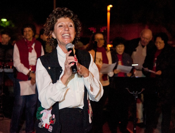Kathy Rash, wife of Chaplain (Lt. Col.) Michael Rash, leads the Nellis chapel's Praise Service Worship Team in holiday song during the Menorah and Tree Lighting ceremony Dec. 7, 2012, at Nellis Air Force Base, Nev. Airmen and their families gathered outside the chapel to ring in the holiday season by singing songs and lighting the tree and menorah. (U.S. Air Force photo by Master Sgt. Jason W. Edwards)