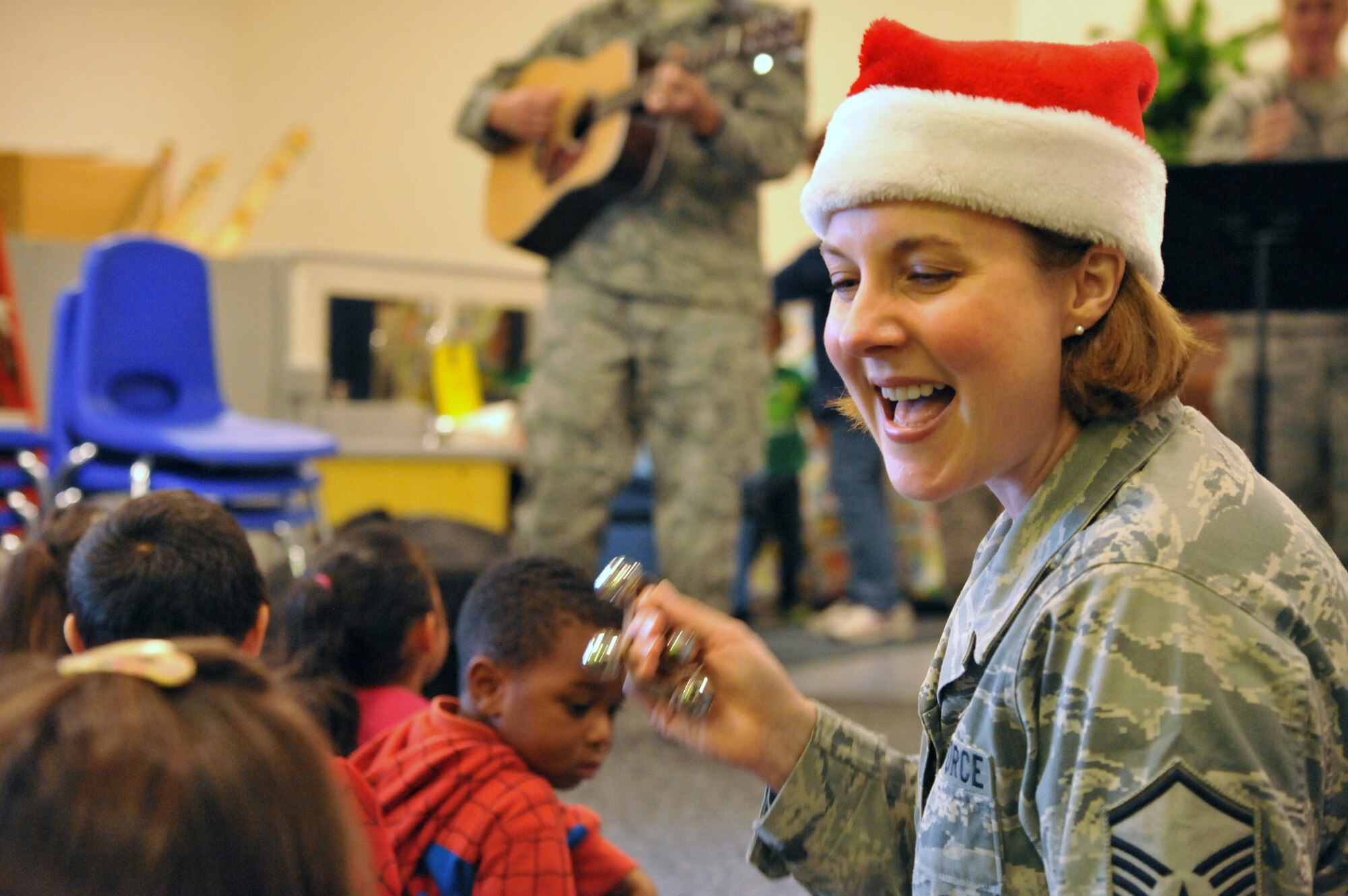 A singer performs a song with the children at the Los Angeles AFB Child Development Center, Dec. 7. Holiday carolers from the Band of the Golden West performed here as part of the group’s annual holiday tour of installations in their operating area. (Photo by Sarah Corrice)