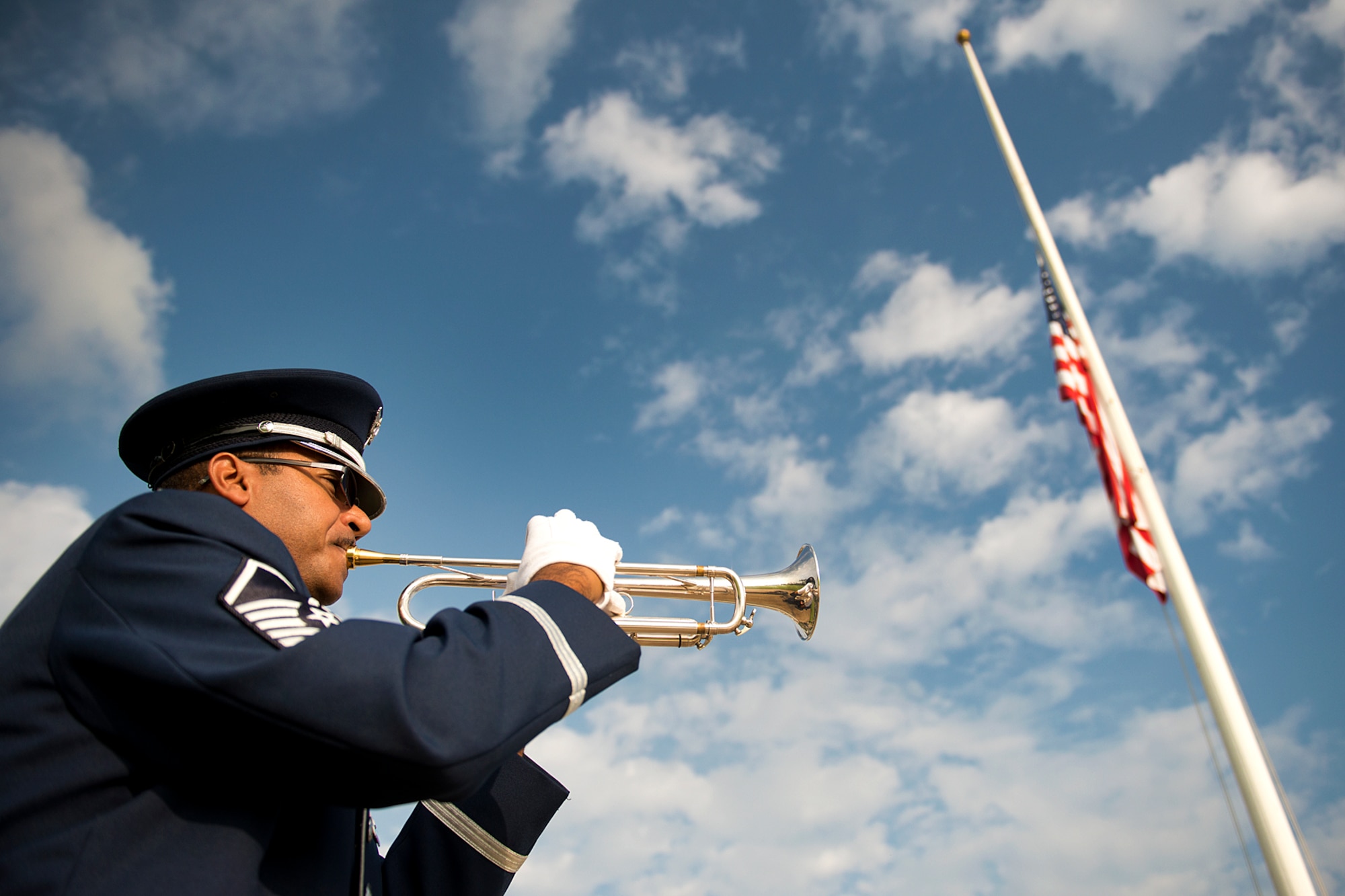 Master Sgt. Brian Hornbuckle, U.S. Air Force Band of the Pacific trumpet player, plays taps during the end of the 71st anniversary ceremony of the surprise attacks on the Hawaiian Islands during a remembrance ceremony Dec. 7, 2012 at Hickam Field, Joint Base Pearl Harbor-Hickam, Hawaii. Airmen, families and veterans gathered at Atterbury Circle, the site of same flag pole that stood Dec. 7, 1941, to commemorate the lives and the sacrifices of the men and women who were there on that day. During the attacks, 189 Army Air Forces Airmen and civilians lost their lives and 303 were wounded. (U.S. Air Force photo/Staff Sgt. Mike Meares)