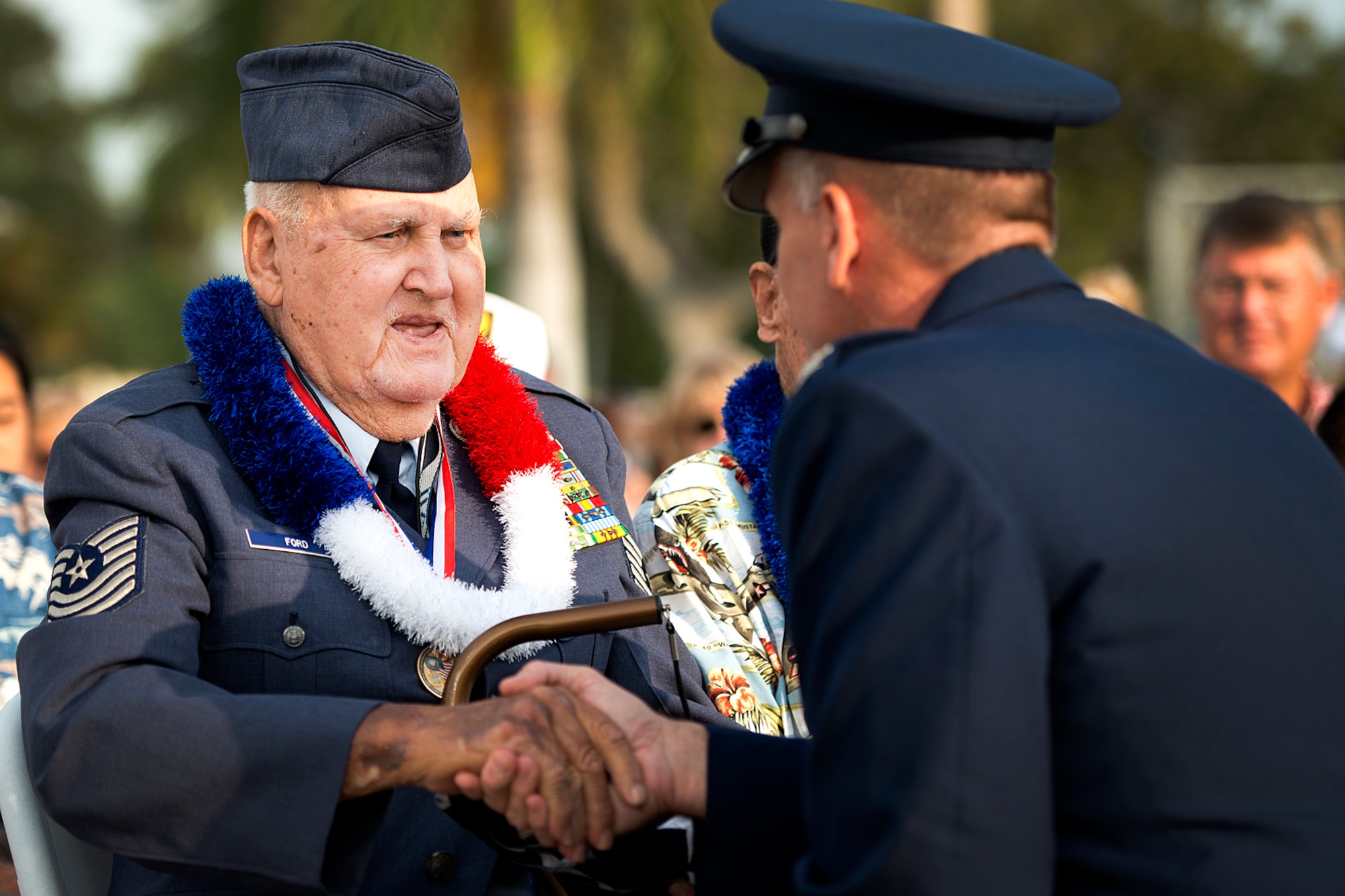 Col. Johnny Roscoe, 15th Wing commander, presents Master Sgt. (Ret.) Ken Ford, a Hickam Field survivor, with a flag to thank him for his service to his country during the 71st anniversary remembrance ceremony on Joint Base Pearl Harbor-Hickam, Dec. 7, 2012. During the attacks, 189 Army Air Corps Airmen and civilians lost their lives and 303 were wounded. Ford served in WWII, Korean War and the Vietnam war during his career. (U.S. Air Force photo/Staff Sgt. Mike Meares)