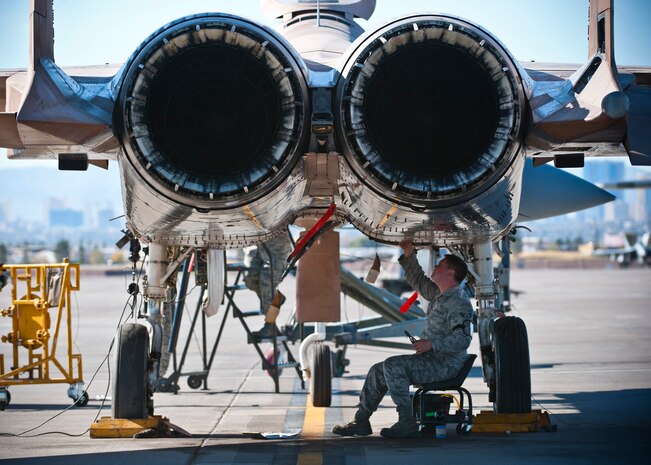 U.S. Air Force Airman 1st Class Bill Bossinger, 757th Aircraft Maintenance Squadron electrical and environmental systems journeyman, tightens wiring underneath an F-15 Eagle during the Mission Employment Phase exercise Dec. 7, 2012, at Nellis Air Force Base, Nev. The exercise is hosted north of Las Vegas on the Nevada Test and Training Range--the U.S. Air Force's premier military training area with more than 12,000 square miles of airspace and 2.9 million acres of land. (U.S. Air Force photo/Senior Airman Brett Clashman)