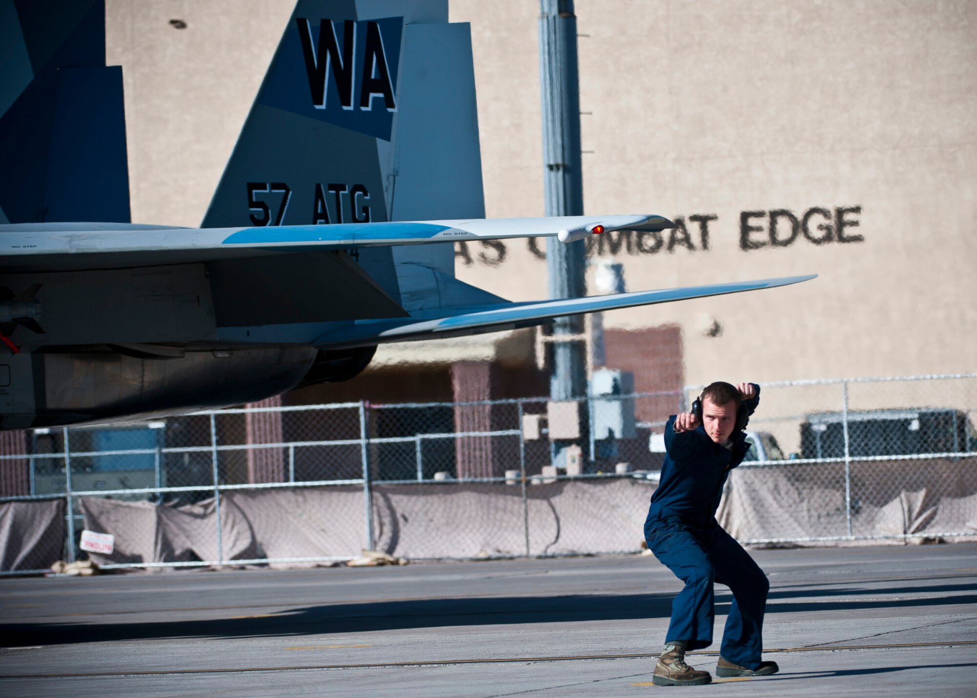 U.S. Air Force Airman 1st Class Wesley Defee, 757th Aircraft Maintenance Squadron crew chief, marshals an F-15 Eagle during the Mission Employment Phase exercise Dec. 7, 2012, at Nellis Air Force Base, Nev. The exercise incorporates Air Force capabilities in diverse scenarios which can include aircraft in conjunction with space and cyberspace assets. (U.S. Air Force photo/Senior Airman Brett Clashman)