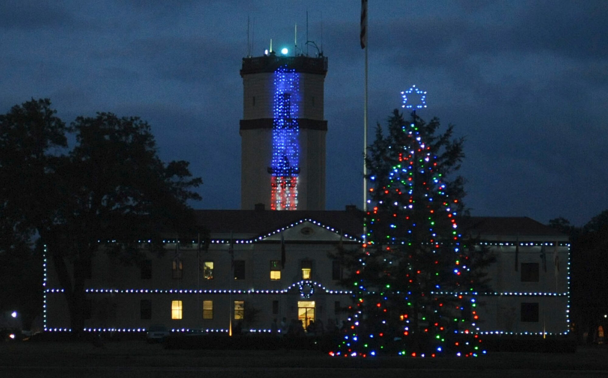 A Holiday tree sparkles in front of the 2nd Bomb Wing Headquarters on Barksdale Air Force Base, La., Dec. 6. More than 100 members of Team Barksdale gathered to watch the annual Holiday tree lighting ceremony and visit with Santa. (U.S. Air Force photo/Senior Airman Kristin High)