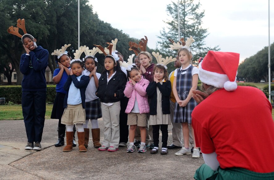Children from the Youth Center are led by Cora Davis, 2nd Force Support Squadron school age development director, in singing "Silent Night" during the annual Holiday tree lighting ceremony on Barksdale Air Force Base, La., Dec. 6. More than 100 members of Team Barksdale gathered to watch the lighting ceremony and visit with Santa. (U.S. Air Force photo/Senior Airman Kristin High)
