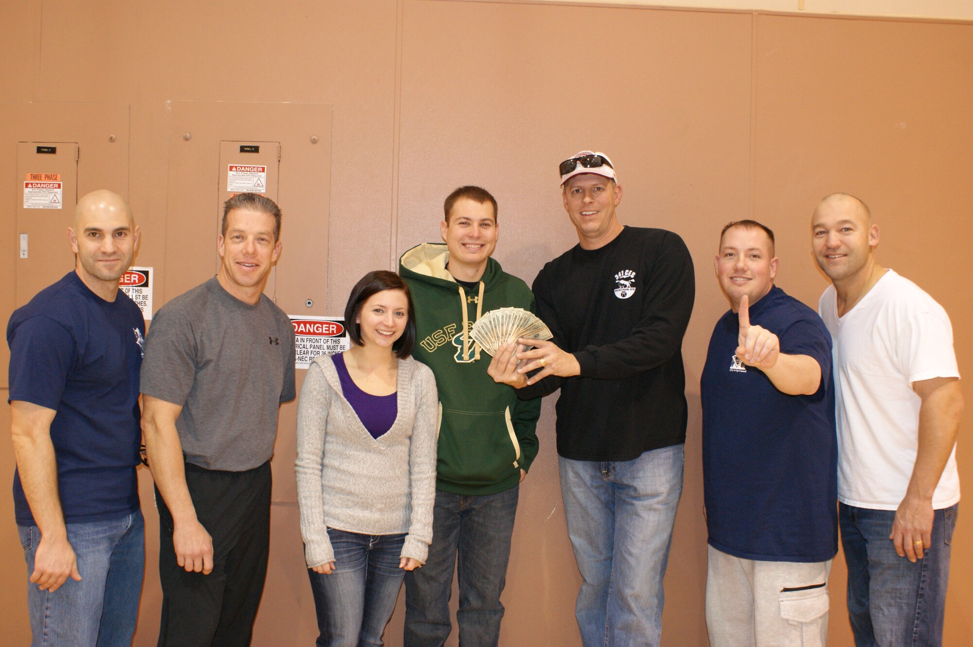 Members of the “Bison Brawlers” team (center) pose with their $300 first place cash prize after winning the scavenger hunt, the fourth of five Operation Holiday Cheer events at the Fitness Center on Dec. 2. Pictured from left to right are Master Sgt. Richard Scavola, 341st Force Support Squadron; Chief Master Sgt. Michael Primo, 341st Missile Maintenance Squadron; 1st Lt. Katherine Mines, 341st FSS; 2nd Lt. Evan Mines, 341st Civil Engineer Squadron; Tech. Sgt. Martin Redenius, 341st CES; Master Sgt. Colin Crandall, 341st Medical Group; and Master Sgt. James Thoma, 341st Maintenance Operations Squadron. More cash and prizes will be given out at the OHC wrap-up party scheduled for Dec. 12 at the Grizzly Bend at 6 p.m. (U.S. Air Force courtesy photo)
