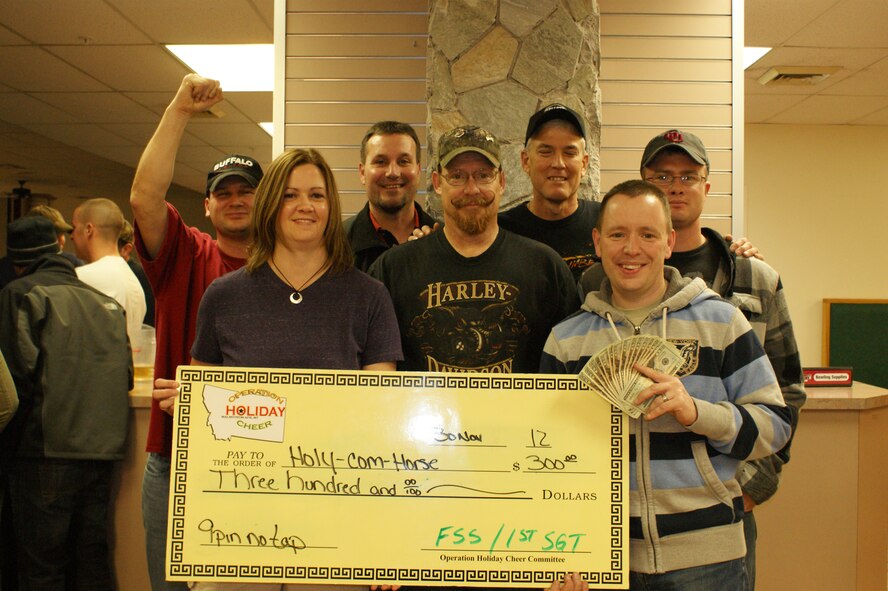 Members of the “Holy-Com-Horse” team pose with their $300 first-place prize for winning the 9-pin, no-tap bowling tournament on Nov. 30, the third of five events for this year’s Operations Holiday Cheer. Pictured from left to right are spectator Master Sgt. Nicholas Sinnott, 341st Medical Operations Squadron; and winners Lisa Dunn, 341st Communications Squadron; Brian Martinez, 341st Communications Squadron; Randy McFadden, 341st CS, Michael Liedle, 341st CS; Chaplain (Capt.) Keith Manry, 341st Missile Wing; and Staff Sgt. Zachary Long, 819th RED HORSE Squadron. (U.S. Air Force courtesy photo)