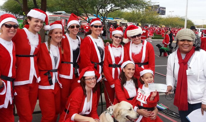 Representatives from the 99th Medical Group Women’s Health Clinic Airmen donate $500 to the Opportunity Village Dec. 1, 2012 after the 2012 Las Vegas Great Santa Run. The 5k charity run raised funds for Opportunity Village, which helps people with mental disabilities through programs such as vocational training, community employment, day services, advocacy, arts and social recreation. The group initially raised the money for the village, but decided to participate in the run as well. (Courtesy Photo)