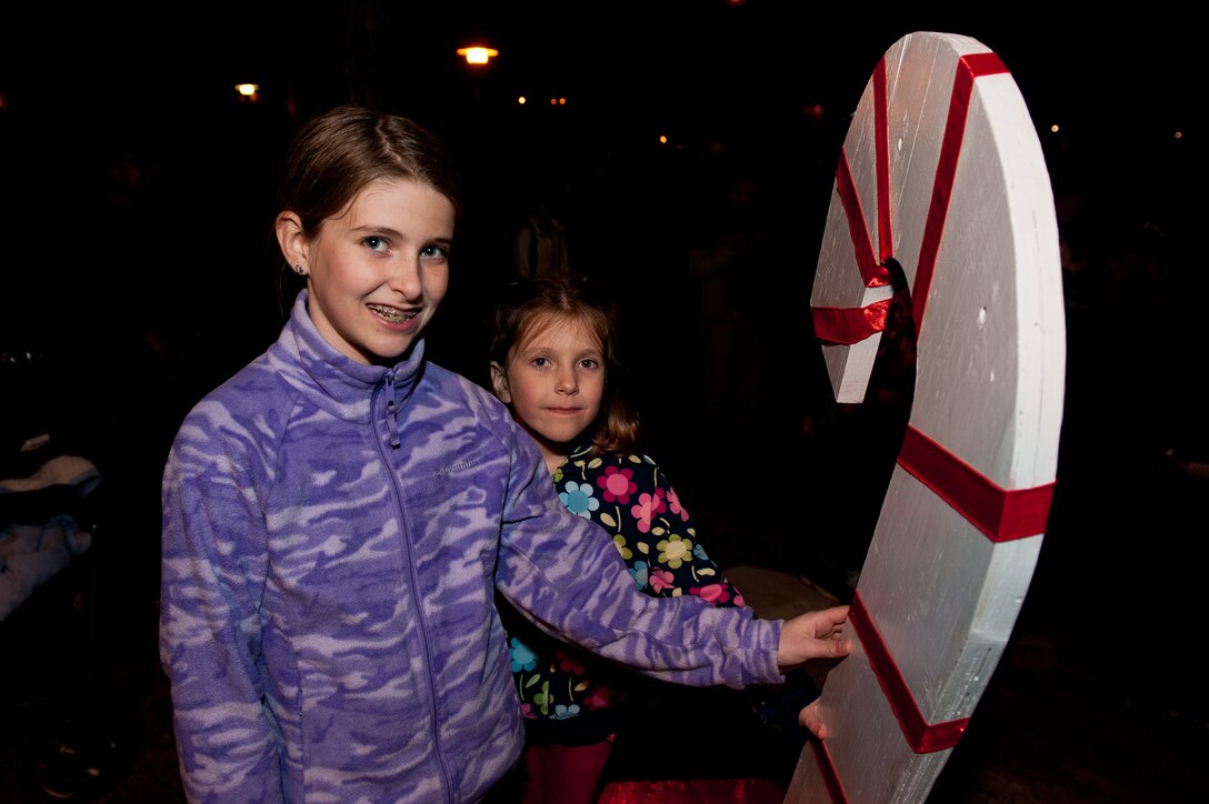 Isabelle, age ten, and Natalie, age six, daughters of Col. Mark Weatherington, 28th Bomb Wing commander, flip the switch to light the base Christmas tree during 28th BW Tree Lighting Ceremony in front of the Freedom Chapel on Ellsworth Air Force Base, S.D, Dec. 5, 2012. Airmen and their families from across the base gathered for the event that kicked off the holiday season. (U.S. Air Force photo by Airman 1st Class Kate Thornton-Maurer/Released)