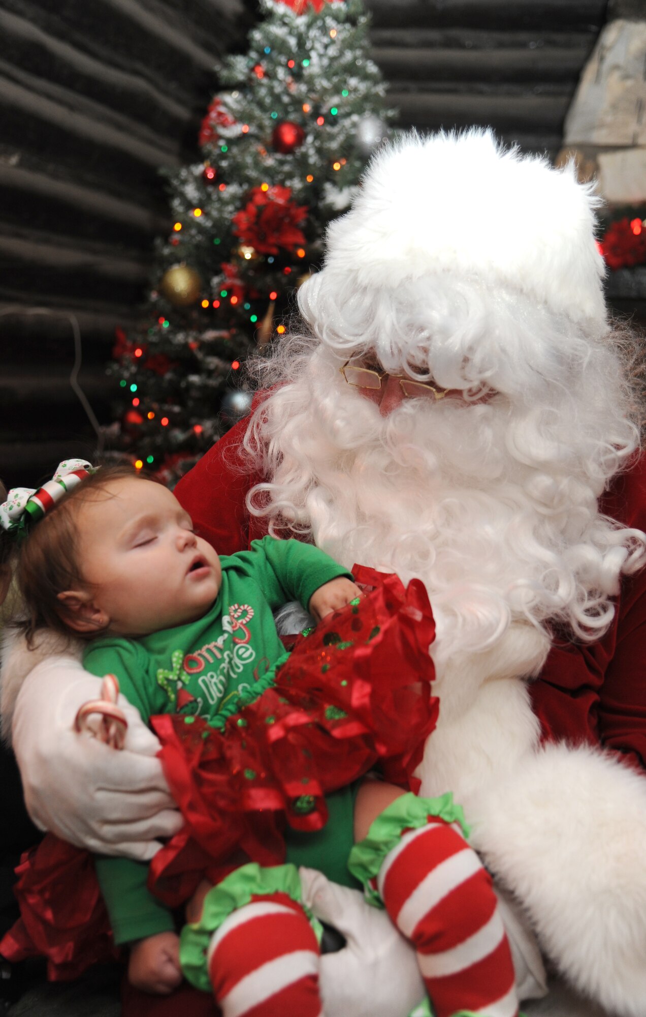 Emma-Lynn Wiley, 9 months, daughter of Kodi and Staff Sgt. Herschal Wiley, 85th Engineering Installation Squadron, sleeps in the arms of Santa Clause at Keesler’s annual Holiday in the Park, Dec. 6, 2012, at marina park, Keesler Air Force Base, Miss.  The event also included a tree lighting ceremony, hay rides, holiday music and free food and beverages.  (U.S. Air Force photo by Kemberly Groue)