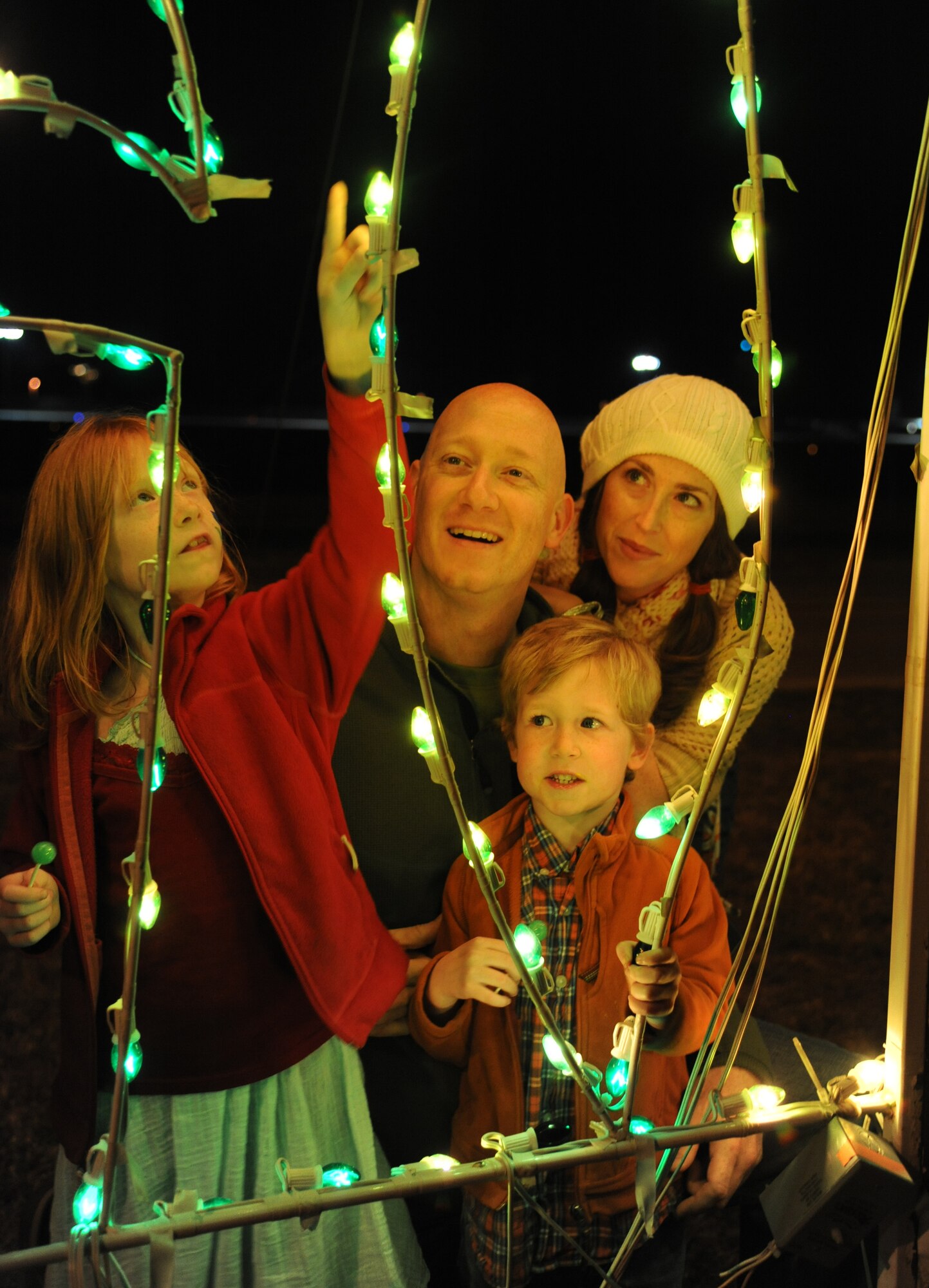 Petty Officer 1st Class Mike DeMauro, Center for Naval Aviation Technical Training Unit, his daughter, Evelyn, 7; wife, Clarissa, and son, Hayden, 4, admire the Christmas light decorations at  Keesler’s annual Holiday in the Park, Dec. 6, 2012, at marina park, Keesler Air Force Base, Miss. The event included a tree lighting ceremony, hay rides, holiday music, visits with Santa and free food and beverages.  (U.S. Air Force photo by Kemberly Groue)