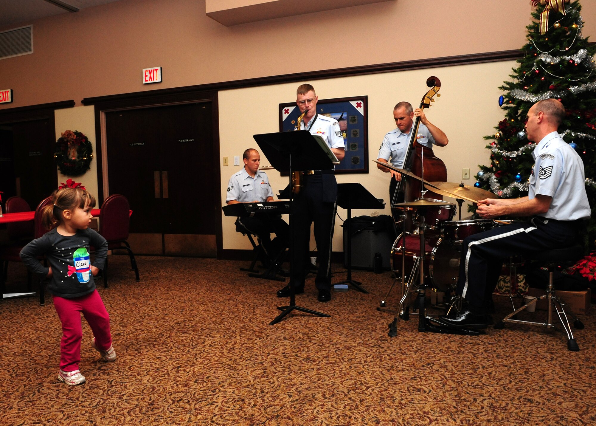 A child, whose father is deployed from Beale Air Force Base, Calif., dances to the music from the Band of the Golden West at the Holiday Hearts Apart Dinner and tree lighting Dec. 7, 2012. The Air Force Band of the Golden West played indoors for the Hearts Apart event while the volunteer band Dingus Moxie and the Flakes played near the base Christmas tree outdoors. (U.S. Air Force photo by Senior Airman Shawn Nickel/Released)