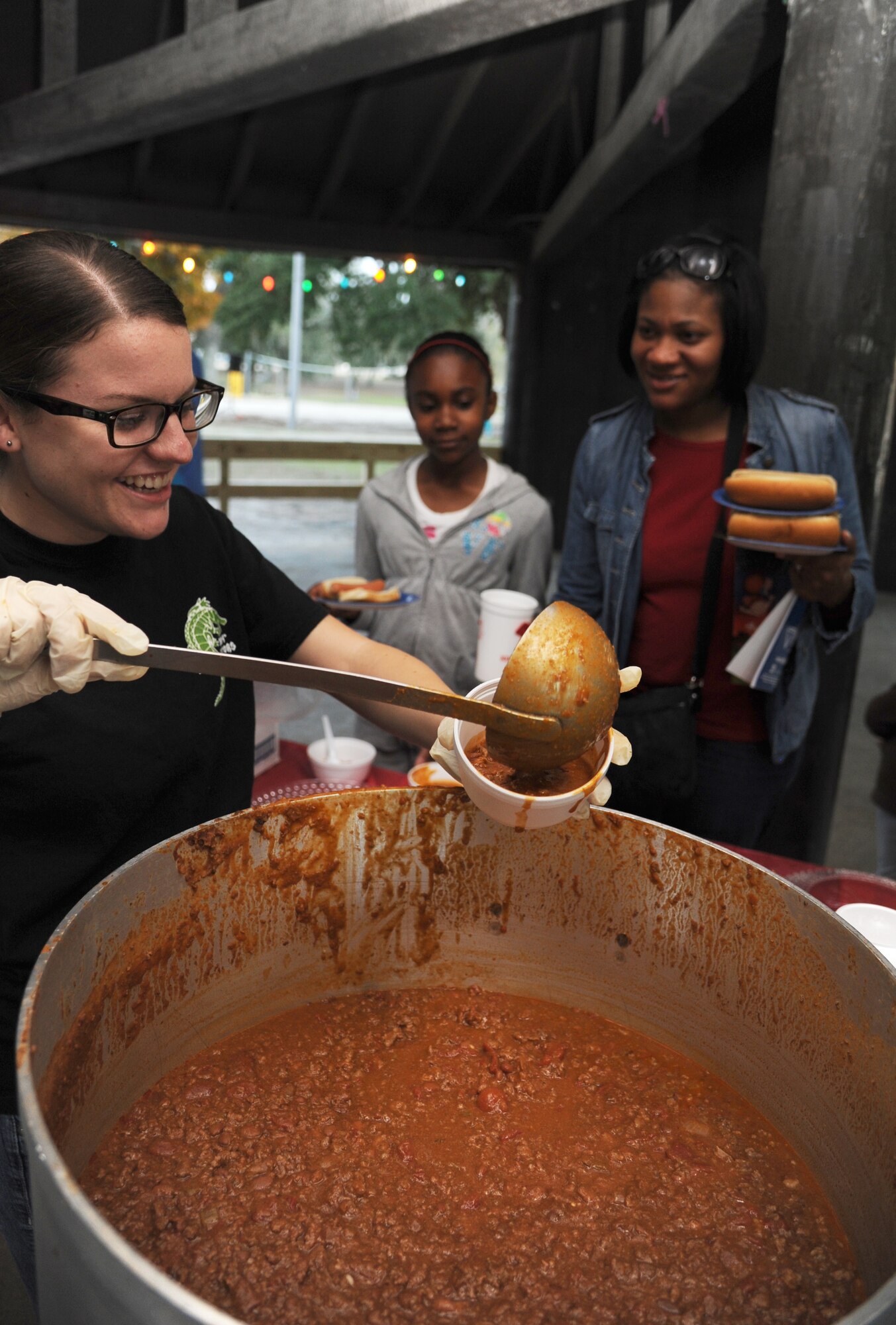 Airman Basic Heather Duff, 334th Training Squadron, serves chili to Kerra Hobbs, 11, and her mother, Kimberly, during Keesler’s annual Holiday in the Park, Dec. 6, 2012, at marina park, Keesler Air Force Base, Miss.  Kimberly is the spouse of Tech. Sgt. Commie Hobbs, Keesler firefighter. The event included a tree lighting ceremony, hay rides, holiday music, visits with Santa and free food and beverages.  (U.S. Air Force photo by Kemberly Groue)