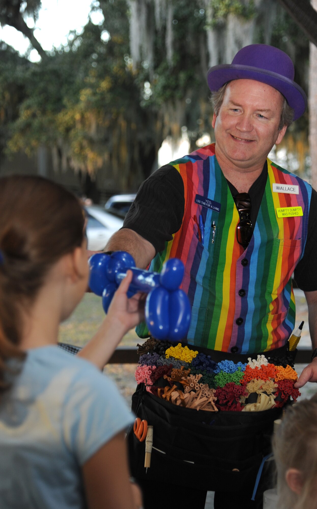 Wallace Farragut, Wally Wizard balloon artist, hands a balloon that he twisted into the shape of a wiener dog to Molly Rains, 12, daughter of Linda and Tech. Sgt. David Rains, 81st Comptroller Squadron, during Keesler’s annual Holiday in the Park, Dec. 6, 2012, at marina park, Keesler Air Force Base, Miss. The event included a tree lighting ceremony, hay rides, holiday music, visits with Santa and free food and beverages.  (U.S. Air Force photo by Kemberly Groue)