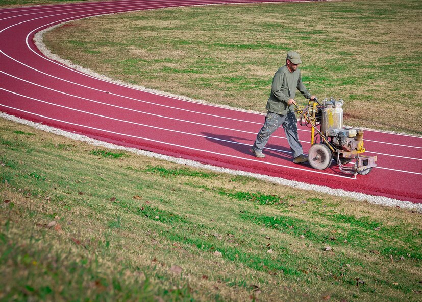 Robb Haynes lays down the final stripe on the newly resurfaced running track at McGhee Tyson ANG Base, Tenn. Haynes walks at a fast pace as he paints the running stripes, averaging five minutes per lap. “Once you get it laid out, the lines go down pretty quick,” he said.  (U.S. Air Force Photo by 2nd Lt. Nathan Wallin)