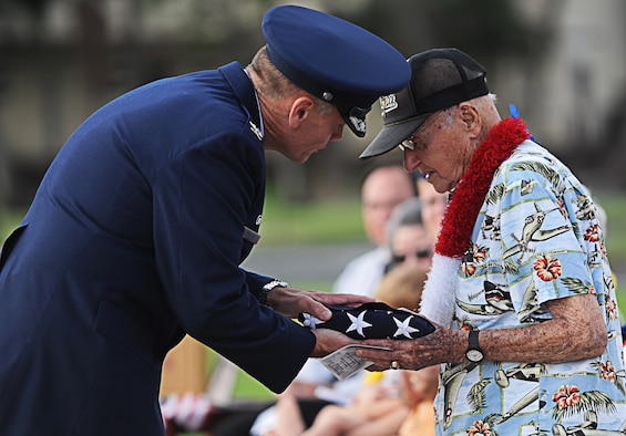 Col. Johnny Roscoe presents a flag to Col. (Ret.) Andrew Kowalski, a Hickam Field survivor, during a 71st Anniversary remembrance Ceremony Dec. 7 at Joint Base Pearl Harbor-Hickam, Hawaii, commemorating the 1941 attacks on Hickam Field. During the attacks, Kowalski reported to the Wing Headquarters building where he assisted the commander and took charge of fielding calls coming in to report casualties. (U.S. Air Force photo/Senior Airman Lauren Main)