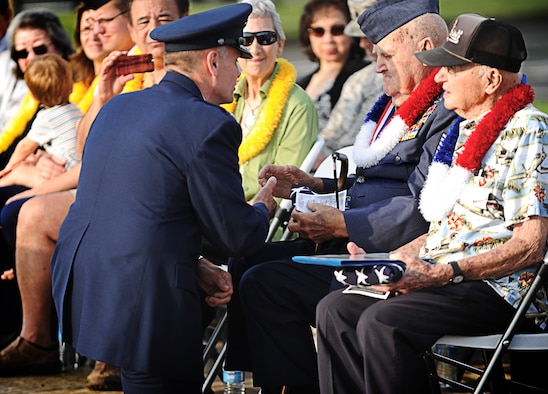 Col. Johnny Roscoe, 15th Wing commander, shakes the hand of Kenneth Ford, a Hickam Field Survivor, during a remembrance ceremony Dec. 7 at Joint Base Pearl Harbor-Hickam, Hawaii. Ford enlisted in the Army Air Corps at the age of 15, after lying about his age. On Dec 6th, he had a layover at Hickam Field en route to Dutch Harbor, Alaska. Early Sunday morning while he was taking a shower, the first bombs dropped on Hickam Field. Ford defended Hickam field on the shores of Ft. Kamehameha Beach. Ford later went on to fight in the European theater, where he became a German prisoner of war. After his eventual release, he fought in both the Korean and Vietnam wars. (U.S. Air Force photo/Senior Airman Lauren Main)