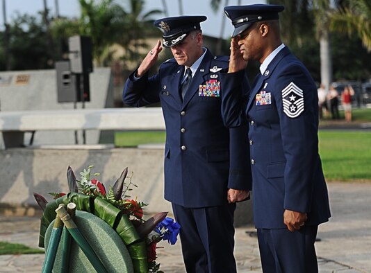 Col. Johnny Roscoe, 15th Wing commander, and Chief Master Sgt. Leslie Bramlett, 15th Wing command chief, salute after placing a wreath at the base of the Joint Base Pearl Harbor-Hickam, Hawaii, flagpole Dec. 7. The wreath laying was part of the remembrance ceremony which is held every year to commemorate the sacrifices made by the men and women of the armed forces during the attack on Hickam field on Dec. 7, 1941. (U.S. Air Force photo/Senior Airman Lauren Main)