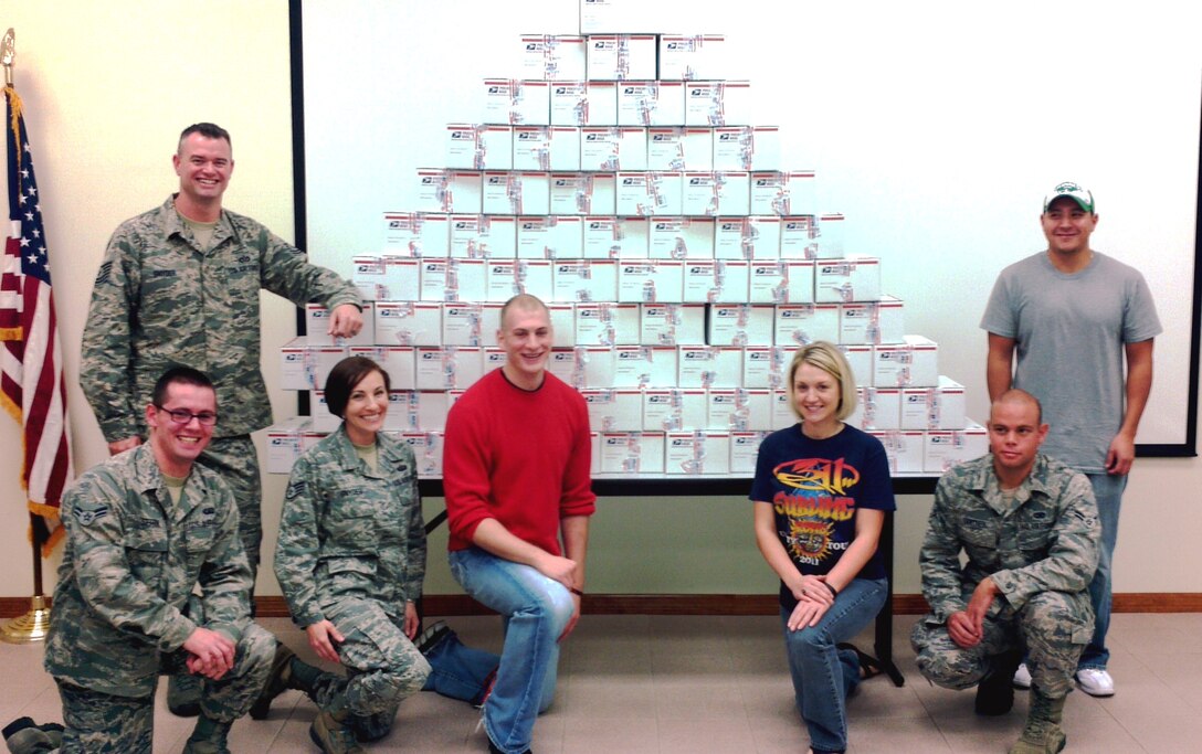 Representatives from the Junior Enlisted Advisory Council pose in front of the care packages (left to right) Tech Sgt. Keith Snyder, 45th Civil Engineer Squadron, Airman 1st Class Dimitri Sefrin, 45th Comptroller Squadron, Staff Sgt. Jessica Snyder, 45th Medical Operations Squadron, Staff Sgt. Philip Primmer, 45th Weather Squadron, Staff Sgt. Dena Forbes, 1st Range Operations Squadron, Airman 1st Class Michael Santner, 45th Mission Support Group, and Tech Sgt. Rigoberto Nunez, 19th Schriever Reserve Unit.