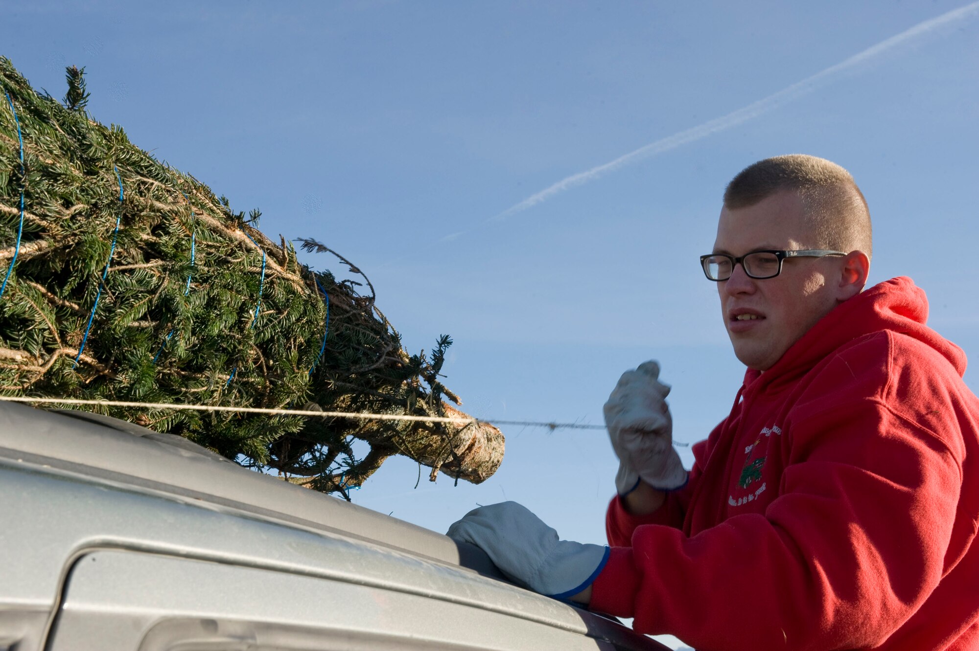 Airman 1st Class Brandon Fowler, 99th Civil Engineer Squadron pavement and equipment operator, secures a tree to a vehicle during the Trees for Troops event Dec. 7, 2012, at Nellis Air Force Base, Nev. More than 50 Nellis Airmen volunteered to unload trees and assist families with selecting a tree. (U.S. Air Force photo by Senior Airman Matthew Lancaster)