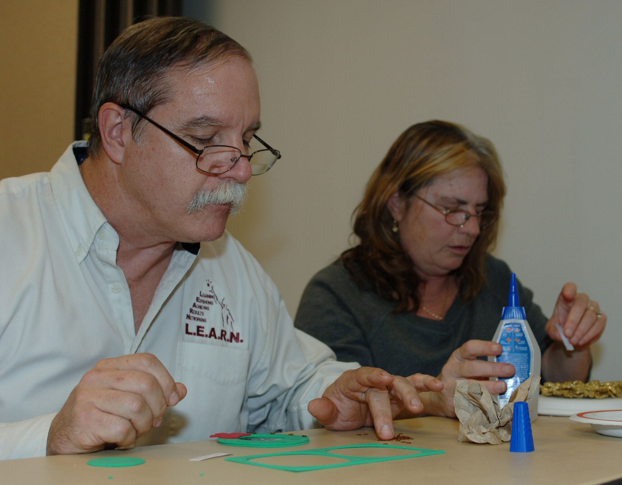 Paul and Kathy Bredlau make an ornament honoring their son Joshua, a fallen Soldier, at the 733rd Mission Support Group headquarters, Dec. 4, 2012. The Survivor Outreach Services office held the event for loved ones to hang ornaments for fallen Service members on a remembrance holiday tree.  (U.S. Air Force photo by Airman 1st Class R. Alex Durbin/Released)