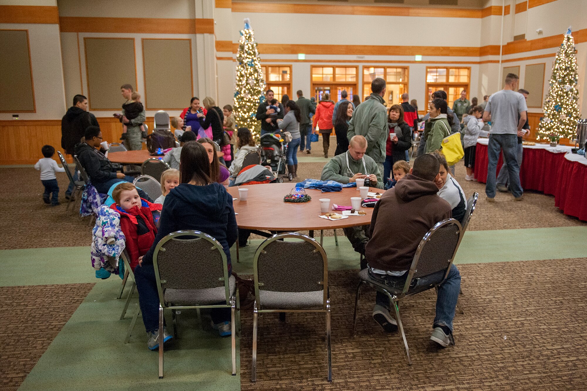 Malmstrom Airmen and their families enjoy the snacks, beverages and camaraderie at the tree lighting ceremony on Nov. 29.  The winners of the Holiday Card Contest were announced in conjunction with this ceremony.  (U.S. Air Force photo/Beau Wade)
