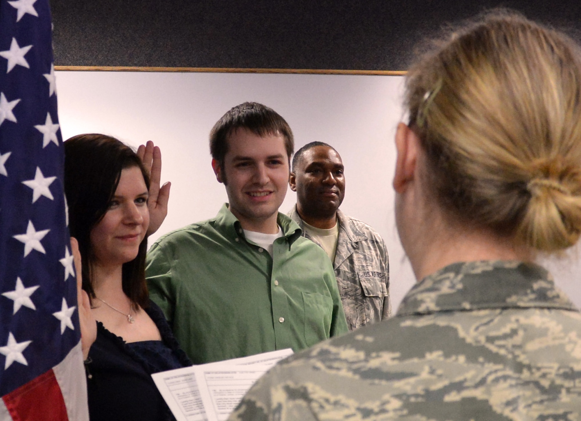 Eric (center) and Ashlee Todd take their oath of enlistment with the Air Force Reserve at the 446th Airlift Wing headquarters building at McChord Field, Wash., Nov. 30, 2012 . Originally, Ashlee was going to be the only enlistee, but thanks to Master Sgt. Charles Loftland (background), a recruiter for the 446th AW, Eric was sold on the honor of joining the Reserve with his wife. (U.S. Air Force photo by Master Sgt. Jake Chappelle)