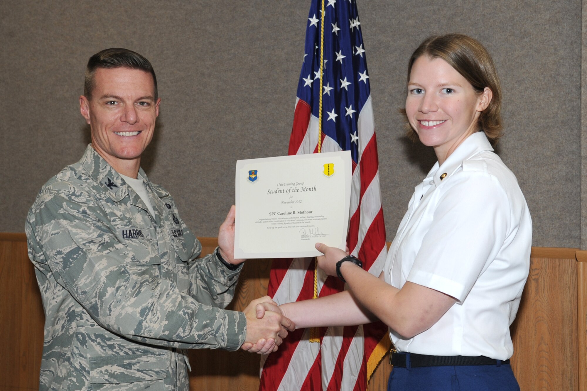 U.S. Air Force Col. Brendan Harris, 17th Training Group commander, presents U.S. Army Spc. Caroline Slothour with the 316th Training Squadron Student of the Month award for November at Goodfellow Air Force Base, Texas, Dec. 7, 2012. (U.S. Air Force photo by Staff Sgt. Laura R. McFarlane)