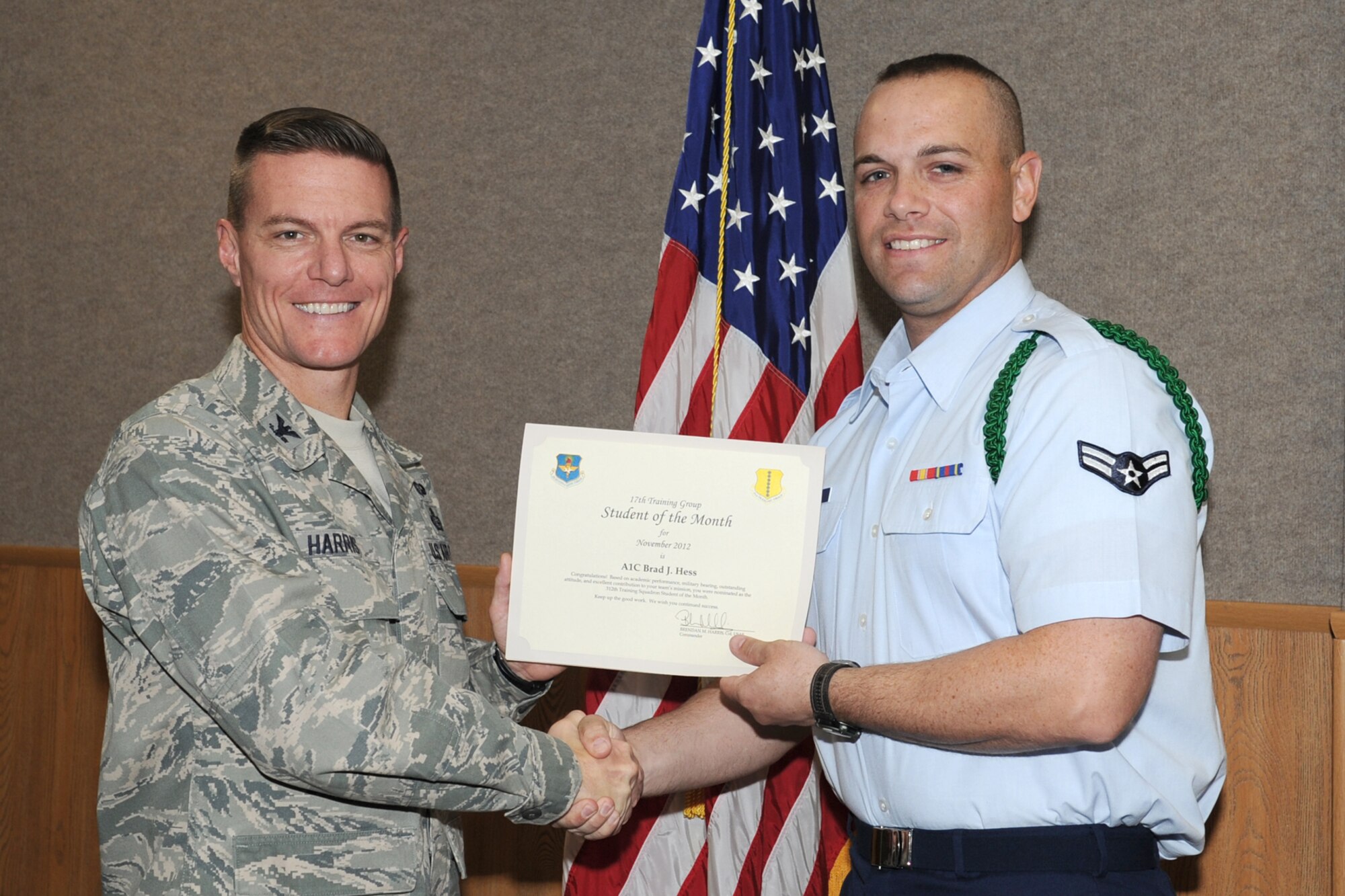 U.S. Air Force Col. Brendan Harris, 17th Training Group commander, presents Airman 1st Class Brad Hess with the 312th Training Squadron Student of the Month award for November at Goodfellow Air Force Base, Texas, Dec. 7, 2012. (U.S. Air Force photo by Staff Sgt. Laura R. McFarlane)