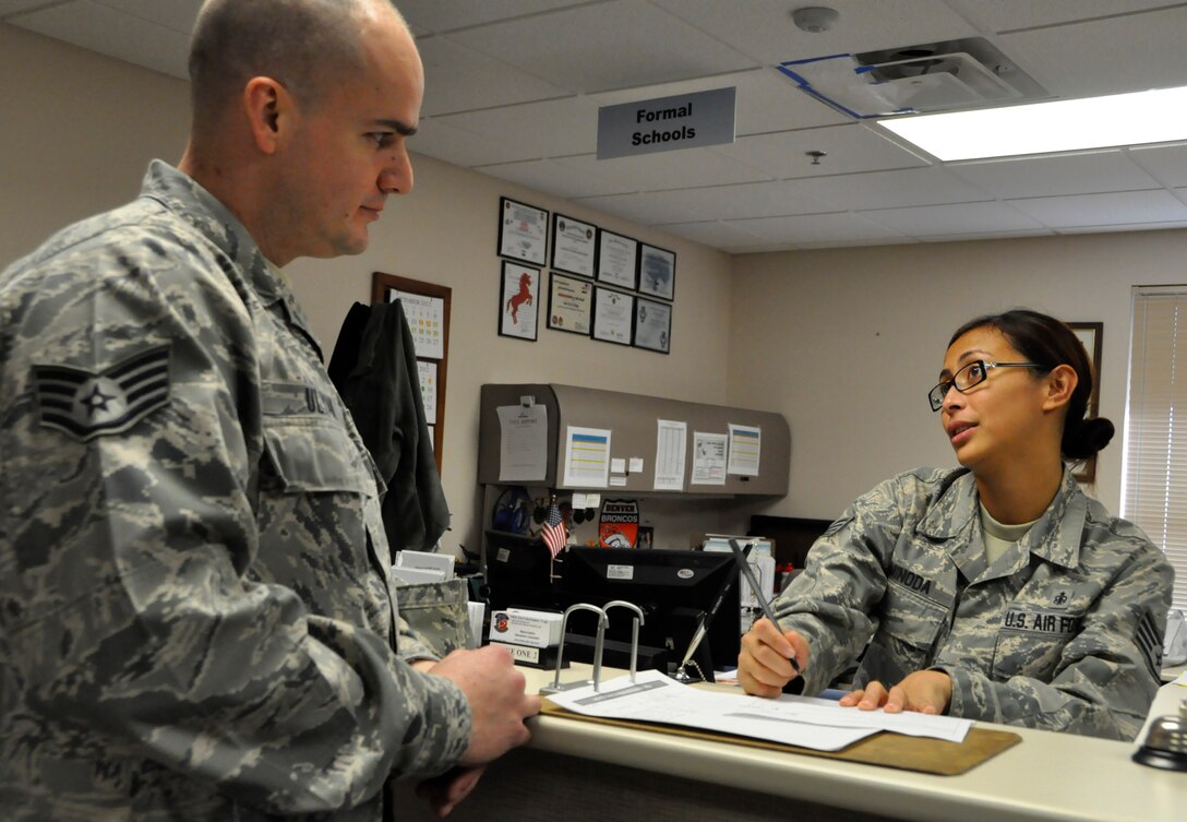 Staff Sgt. Chustine Minoda, an education and training apprentice with the 446th Force Support Squadron, speaks with Staff Sgt. John Ulyak about his education benefits as she signs his in-processing checklist Dec. 1. Minoda recently cross-trained into Education and Training from health administrative management. The Education and Training Flight is looking for three traditional Reservists to join their team. (U.S. Air Force photo/Staff Sgt. Rachael Garneau)