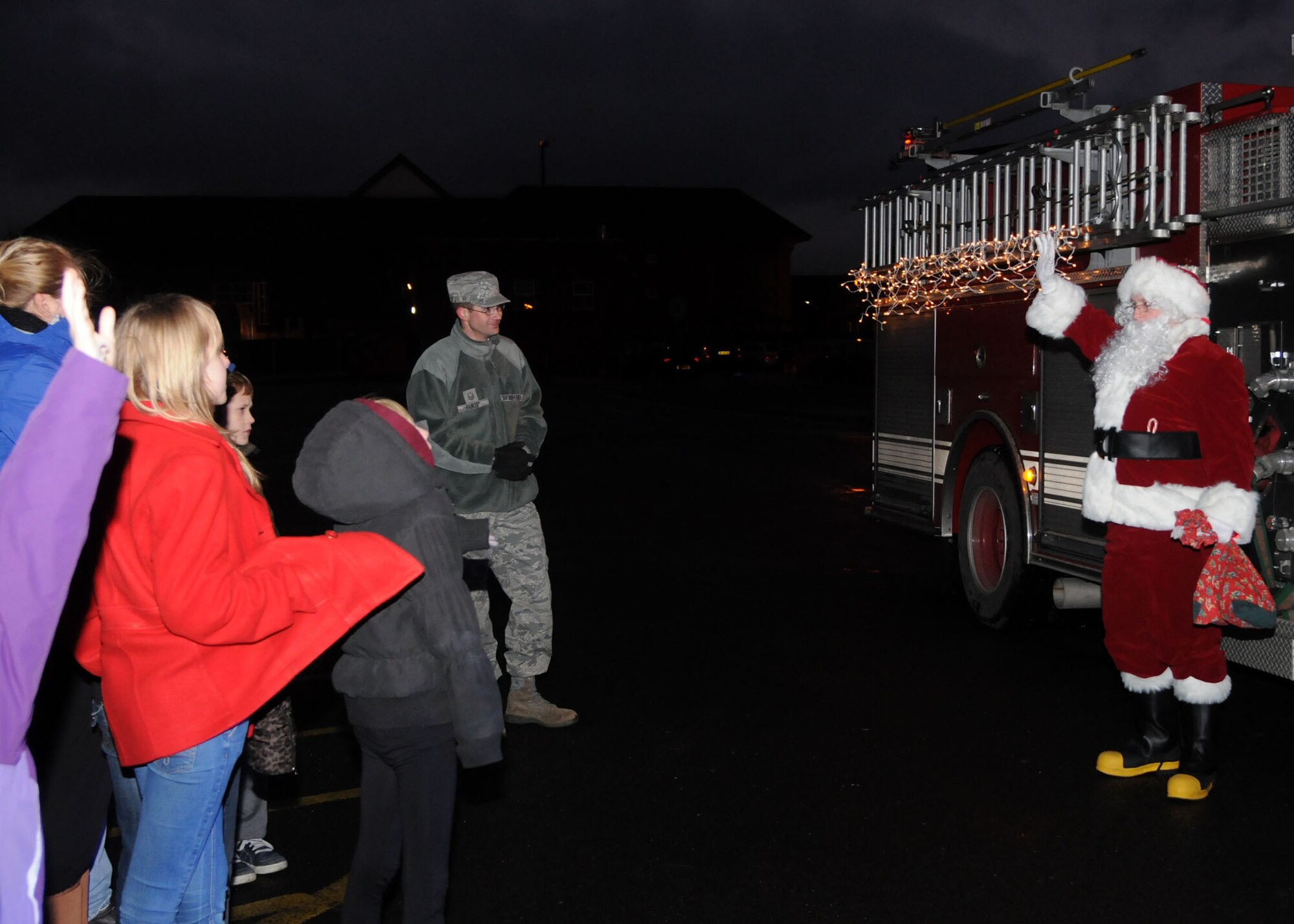 Santa Claus makes a surprise visit to the annual Christmas tree lighting ceremony Dec. 7, 2012, at RAF Mildenhall, England. Santa Claus arrived at the tree lighting on the back of a fire truck.(U.S. Air Force photo by Airman 1st Class Kelsey Waters/Released)