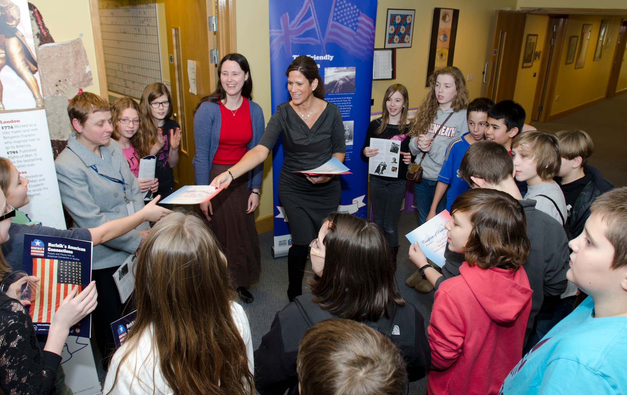 ROYAL AIR FORCE FELTWELL, England - Juliet Ramos, Department of Defense Dependents Schools, Isles District instructional systems specialist in social studies for middle school and high school, passes out certificates of appreciation to students who worked on the Connecting People: Norfolk's American Connections exhibit at Lakenheath Middle School Dec. 5, 2012. More than 150 children, ages 7-12, from 10 schools worked on the exhibit in early 2012. Approximately 25,000 people viewed the exhibit across 120 venues in Norfolk. (U.S. Air Force photo by Staff Sgt. Stephen Linch)