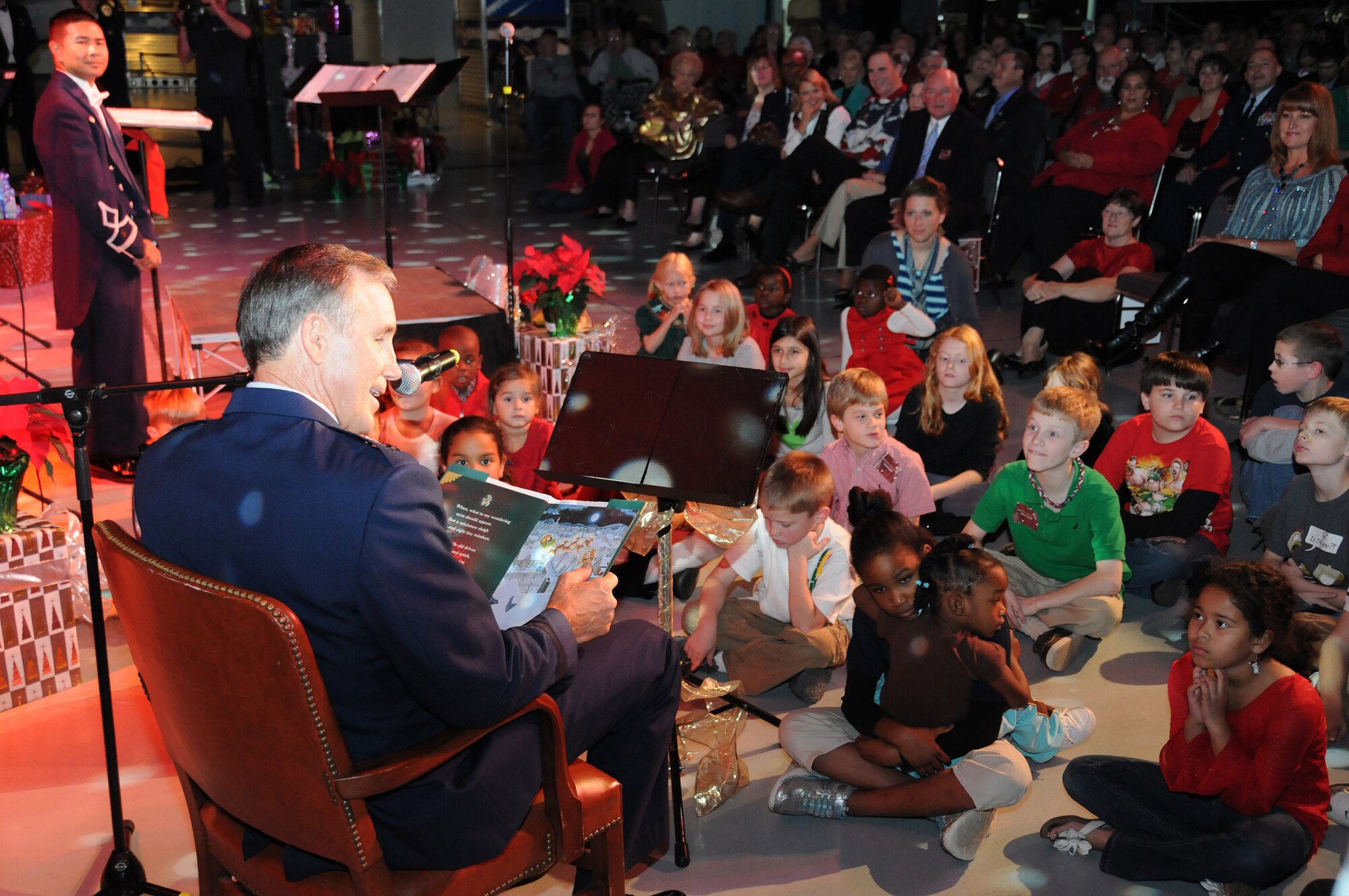 Maj. Gen. Craig Neil Gourley, Air Force Reserve Command vice commander, reads "T’was the Night Before Christmas" to children during the 51st Annual Holiday Concert at the Museum of Aviation at Robins Air Force Base, Ga., Dec. 6. Looking on is 2nd Lt. Thomas Gamboa, Band of the Air Force Reserve commander and conductor. (U.S. Air Force photo/Senior Airman Katie Spencer)