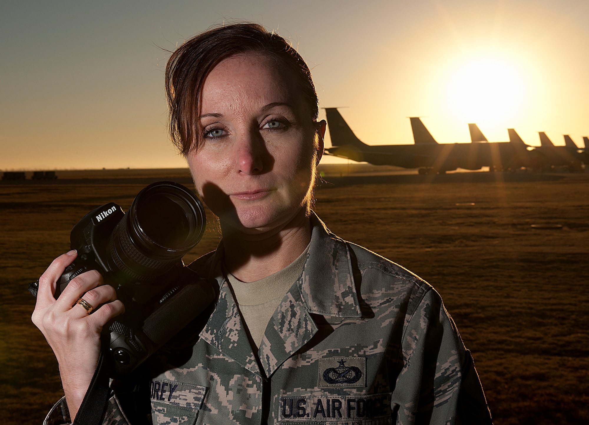 Master Sgt. Rebecca Corey holds her most important tool, the camera, at the flightline on Altus Air Force Base, Okla., Dec. 6, 20120. After her 2009 deployment to Ghazni province, Afghanistan, as a combat photographer, Corey struggled with life-altering post-traumatic stress disorder. Today, she is the NCO in charge at the 97th Air Mobility Wing. (U.S. Air Force photo/) 
