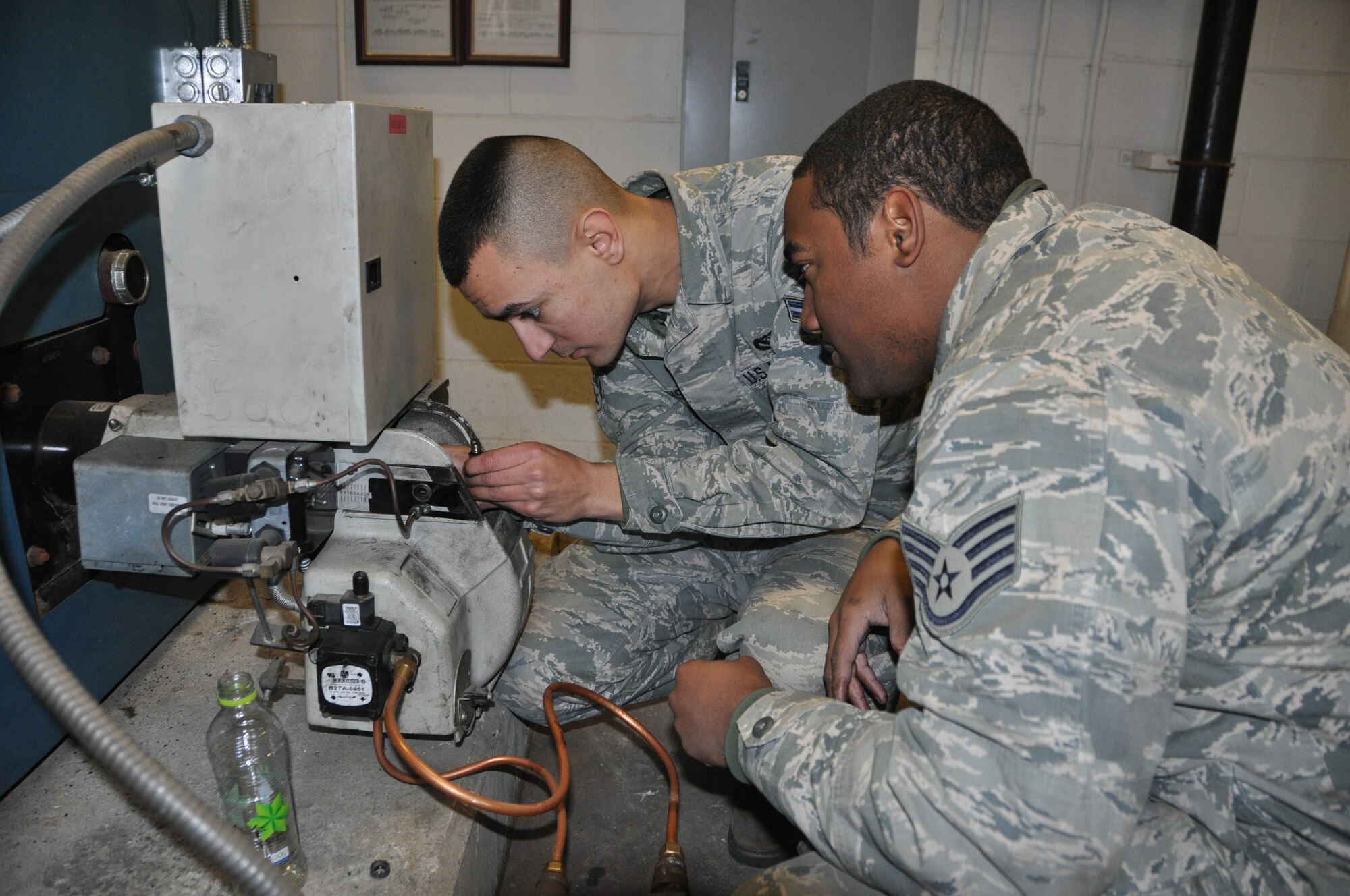 Airman 1st Class Colin Josephson, 51st Civil Engineer Squadron Heating Ventilation and Air Conditioning apprentice, and Staff Sgt. Yohance Leslie, 51st CES journeyman, performs a regular inspection for a boiler in Bldg. 936 to ensure it is functioning properly, Dec. 3, 2012, at Osan Air Base, Republic of Korea. HVAC has the Reoccurring Work Program designed to make sure regular inspections are done for facilities and critical buildings on the installation. This program takes preventative action to avoid potential mishaps or to fix problems before boilers or ventilation systems become problematic. (U.S. Air Force photo/Senior Airman Kristina Overton)