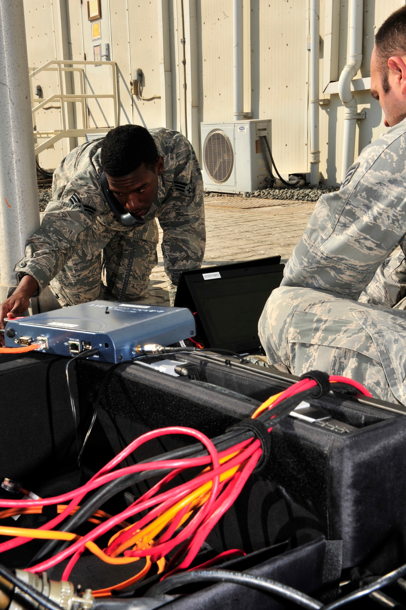 SOUTHWEST ASIA -- U.S. Air Force Staff Sgt. Bradley Keszler and Senior Airman Garrett Rhodes, 380th Expeditionary Communications Squadron radio frequency transmissions system technicians, participate in a weekly operations check of the Communications Fly-Away Kit (CFK) Nov. 3, 2012. Communications personnel demonstrate their ability to set-up the Non-Secure Internet Protocol Router, Secure Internet Protocol Router, and Voice Over Secure Internet Protocol within 30 minutes during emergencies and contingencies.  (U.S. Air Force photo/Tech. Sgt. Christina M. Styer) (RELEASED)