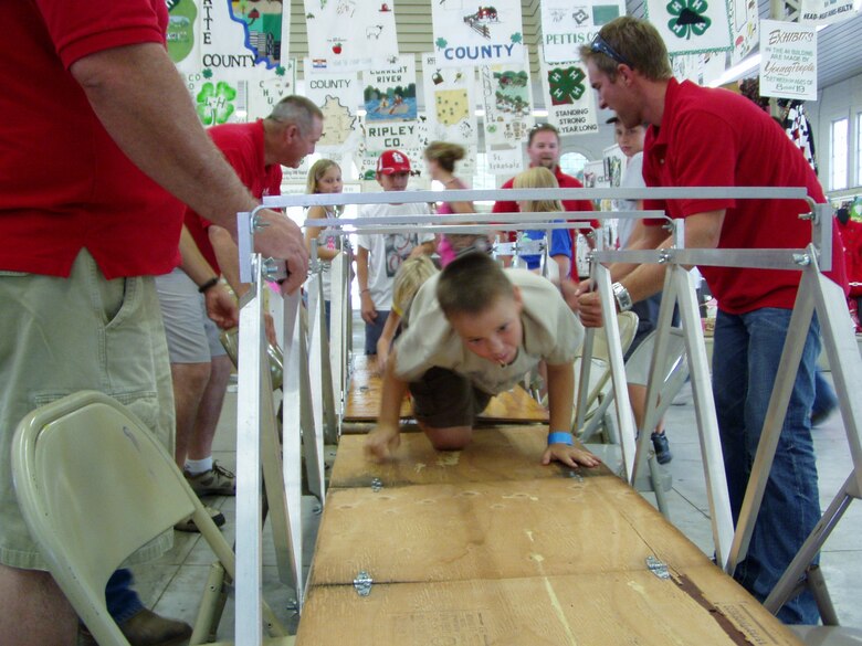 Volunteers assist as children raise a small, aluminum and wood bridge replica at the Missouri State Fair. This was part of an effort to educate the kids on civil engineering. Photo provided.