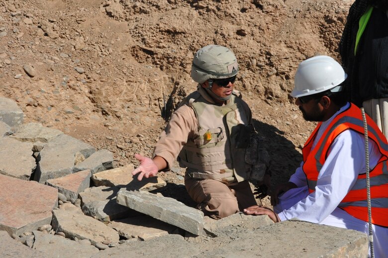 Benny Apuya, (left) a quality assurance and construction representative with the Afghanistan Engineer District-South, inspects stone work at the Kandahar Regional Military Training Center project Nov. 18.  Apuya visits the site several times a week to make sure construction complies with plans and specifications as well as International Building Code standards. 
