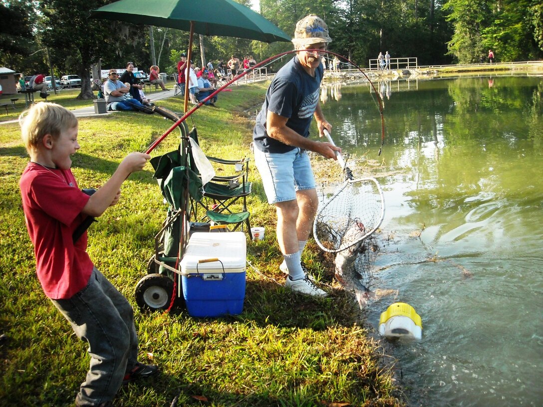 An unidentified man helps land a fish during the annual Kids Fish Day at Town Bluff/BA Steinhagen Lake on May 12, 2012.        