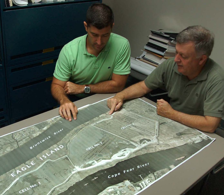 Wilmington District civil engineers Carl Baynard, left, and Ben Lackey review plans for building three separate cells higher for Eagle Island, a dredge material disposal site in Wilmington. The cells are near capacity from dredged material from the nearby Cape Fear River and the cell perimeters need to be higher to accommodate new material.  