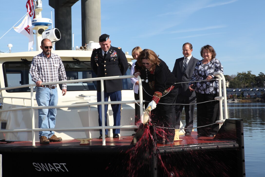 Connie Swart Pettit, daughter of Dirk Swart, christens the SWART with a bottle of champagne at the Engineer Yard. Watching is Wilmington District Commander Col. Steve Baker and Pettit's sisters Penny Swart Ledbetter, Lynda Swart Davis, and brother Dirk Swart IV. At left is SWART Captain Wick Westmoreland. (USACE photo by Kenneth Velez)
