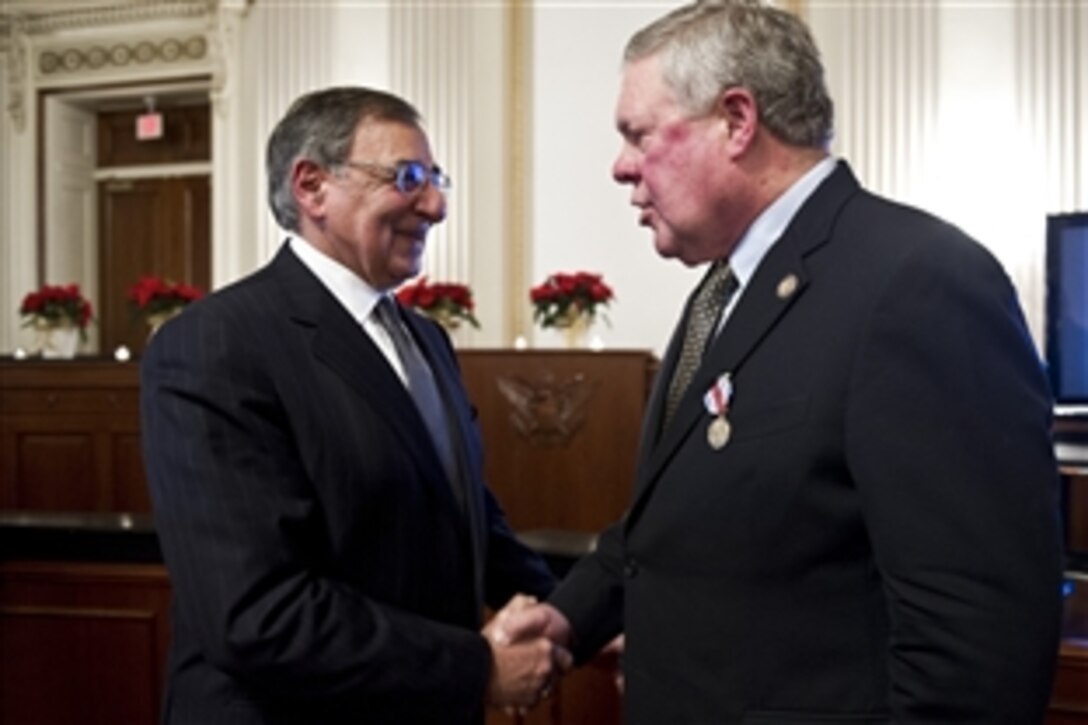 Defense Secretary Leon E. Panetta, left, presents U.S. Rep. Norm Dicks of Washington, right, with the Distinguished Public Service Medal, the highest award the department can give a civilian, at the Cannon House Office Building in Washington, D.C., Dec. 6, 2012. 